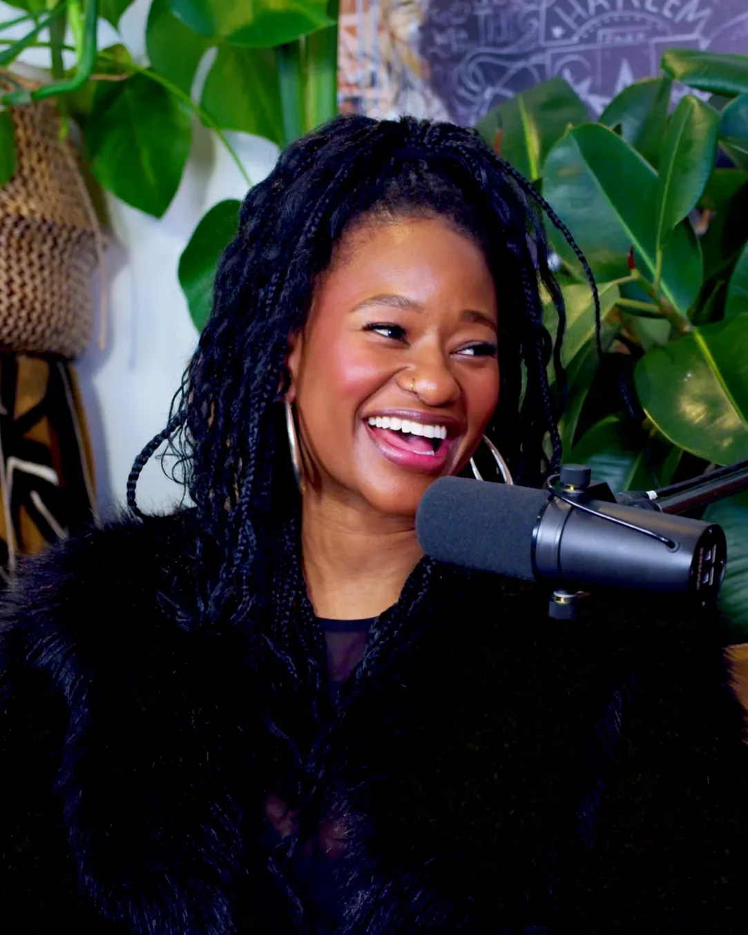 Mati mid-laugh at the podcast microphone
